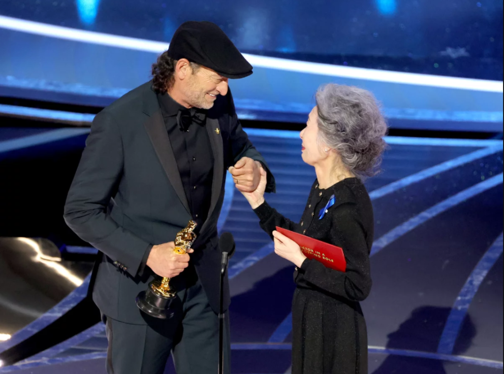 Troy Kotsur accepts the Actor in a Supporting Role award for CODA from Youn Yuh-jung onstage during the 94th Annual Academy Awards at Dolby Theatre on March 27, 2022 in Hollywood, California.